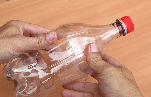 庭と果樹園のために手で持っているペットボトルの新しい工芸品